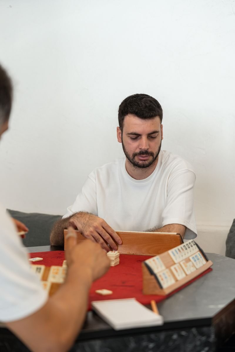 A focused man enjoys a board game with friends at home, fostering togetherness.
